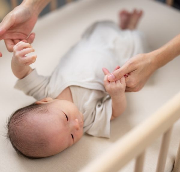 Mum,Hold,With,Her,Newborn,Baby,Hand,On,Baby,Cot