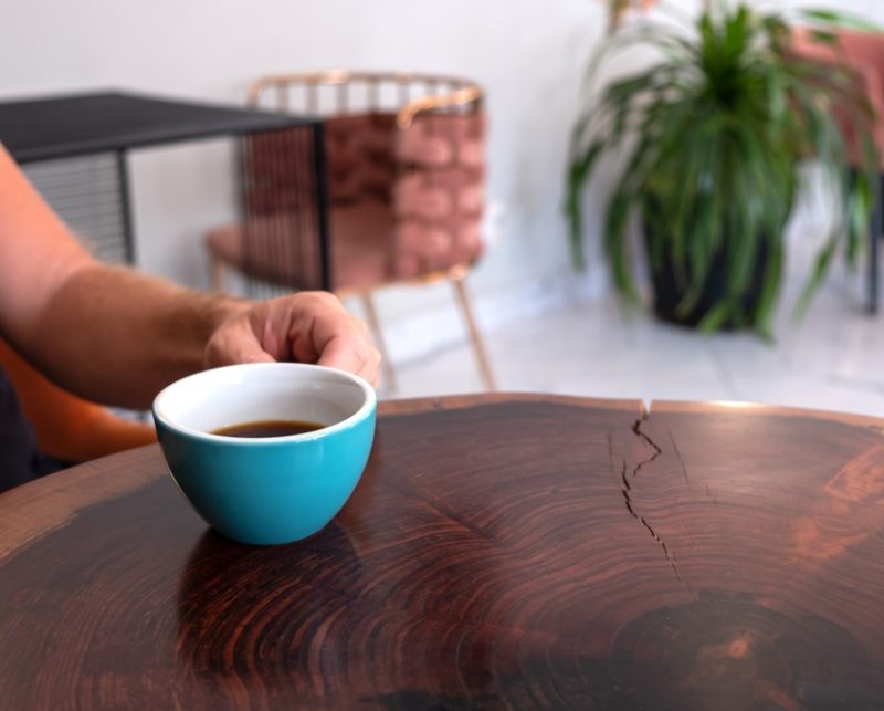 A,Man,Sitting,By,The,Table,In,A,Cafe,And