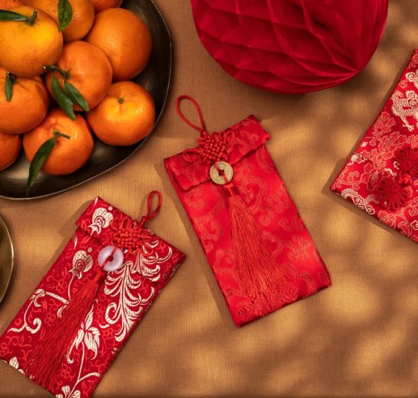 A,Plate,Of,Oranges,And,Red,Gift,Envelopes,On,A