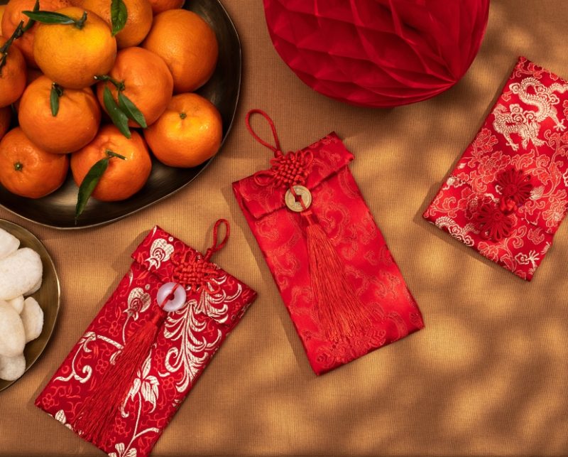 A,Plate,Of,Oranges,And,Red,Gift,Envelopes,On,A